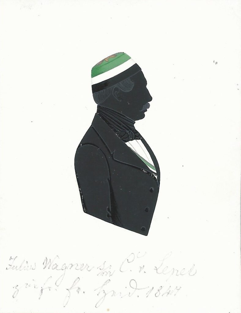 Julius Ludwig Friedrich Wagner wurde am 30. Dezember 1816 in Uiffingen (heute Stadtteil von Boxberg) geboren und am 5. Januar 1817 protestantisch getauft. Sein Vater war der Pastor Peter Wagner (1772-1853), seine Mutter dessen Ehefrau Louise Friederika Wilhelmina geb. Kleinpell (1781-1865). Er immatrikulierte sich am 7. November 1838 an der Universität Heidelberg für das Studium der Rechtswissenschaften und trat dem Corps Guestphalia bei. In dieses wurde Wagner 1839 recipiert. Die Charge des Seniors bekleidete er zweimal und später wurde er zum Ehrenmitglied seines Corps ernannt. Nach dem Abschluss seines Studiums heiratete er am 10. Juli 1849 Emilie Marie Schneider (1820-1896) in Aglasterhausen. Zusammen mit ihr und den gemeinsamen Kindern wanderte er in die Vereinigten Staaten aus. Dort war er als Farmer und Postmeister tätig und starb am 16. Februar 1903 in Chicago. Die Silhouette ist mit der Widmung "Julius Wagner s/m C. v. Lepel zur fr. Er. Heid. 1847" versehen. Ehemals Sammlung Robert Soppa Saxoniae Konstanz, jetzt andere namentlich nicht genannte Privatsammlung.