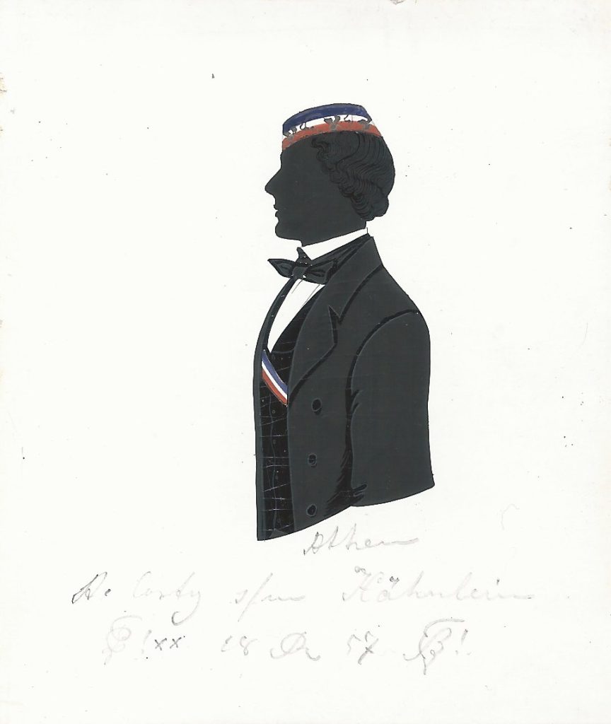 Alexander Costy stammte aus Athen. Er immatrikulierte sich zunächst am 14. April 1856 als stud. phil. an der Universität zu Bonn und wechselte das Studienfach im folgenden Semester zu Jura. Gleich zu Beginn seines Studiums wurde er bei Palatia aktiv und noch im selben Jahr in diese recipiert. Er war zweimal Consenior und wechselte Michaelis 1857 an die Universität Berlin, wo bereits ein Verwandter - vielleicht ein Bruder - immatrikuliert war und mit dem er sich fortan eine Adresse teilte. Costy wurde in Berlin zu Beginn 1858 ein weiteres Mal bei Marchia aktiv, wo er einmal Consenior und einmal Senior war. Laut Kösener Corpsliste verstarb er einerseits bereits 1858, war aber andererseits griechischer Konsul und Advokat. Da er auch im Berliner Verzeichnis der Studierenden des Sommersemesters 1859 und Wintersemesters 1859/60 geführt wird, scheint er wohl erst später verstorben zu sein. Die Silhouette ist gewidmet "Athen - A. Costy [Z!] s/m Hähnlein [Z!] 18 [R] 57". Sammlung Robert Soppa Saxoniae Konstanz
